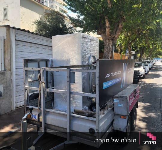 עגלה עם מקרר עטוף בניילון ברחוב, קשור עם רצועות